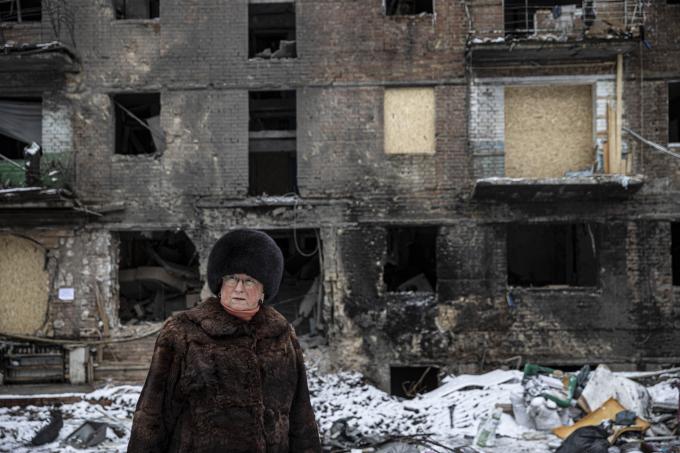 Een vrouw voor een beschadigd woongebouw als gevolg van de oorlog tussen Rusland en Oekraïne. Foto: ANP / Metin Aktas / Anadolu Agency